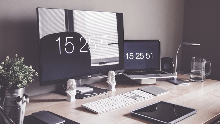 MacBook on the desk with an external monitor. The time is displayed on the MacBook and the monitor.