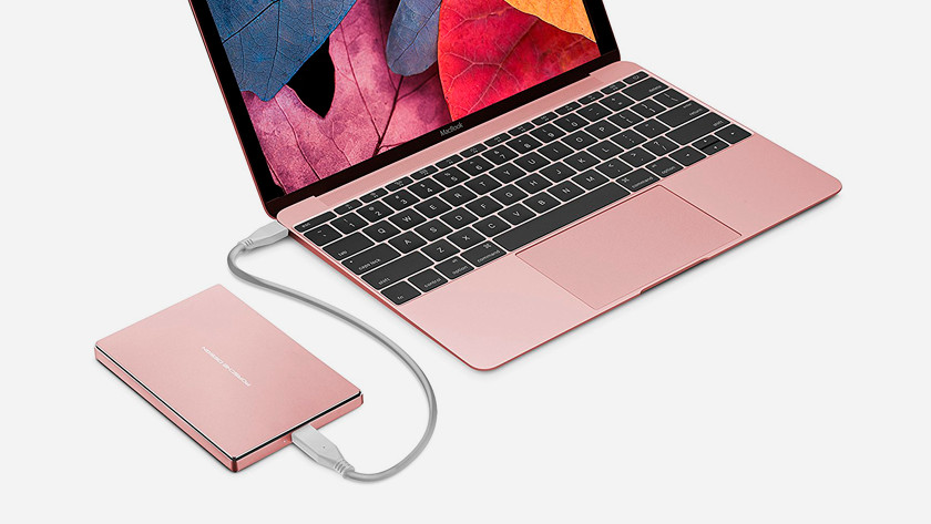 MacBook rose gold with external hard drive in rose gold.